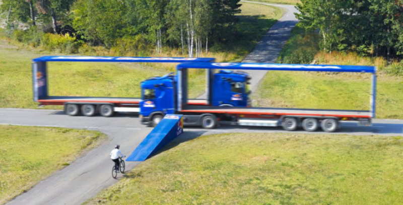 🎥 Mountainbiker springt door twee rijdende vrachtwagens tegelijkertijd